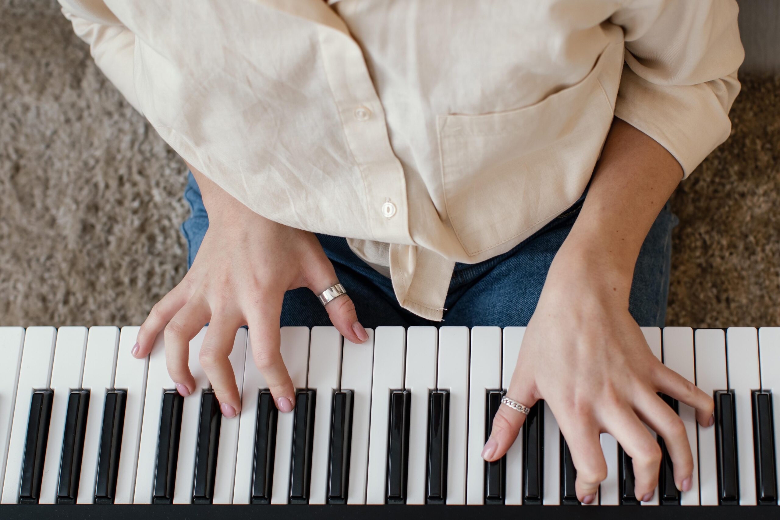 top-view-female-musician-playing-piano-keyboard